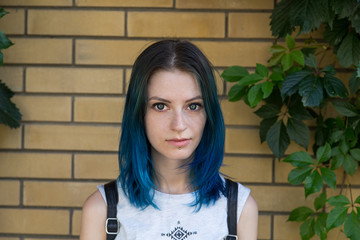 Wall Mural - Blue haired girl posing on the background of ivy