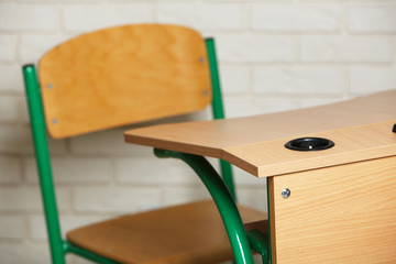 Wall Mural - School desk and chair on white brick wall background