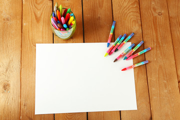 Canvas Print - Colorful pastel crayons with white sheet of paper on wooden background