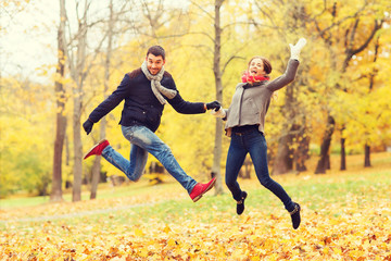 Canvas Print - smiling couple having fun in autumn park