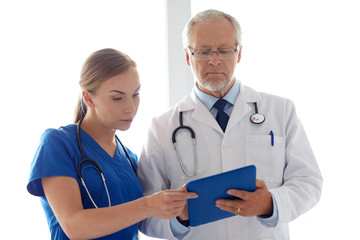 Poster - senior doctor and nurse with tablet pc at hospital