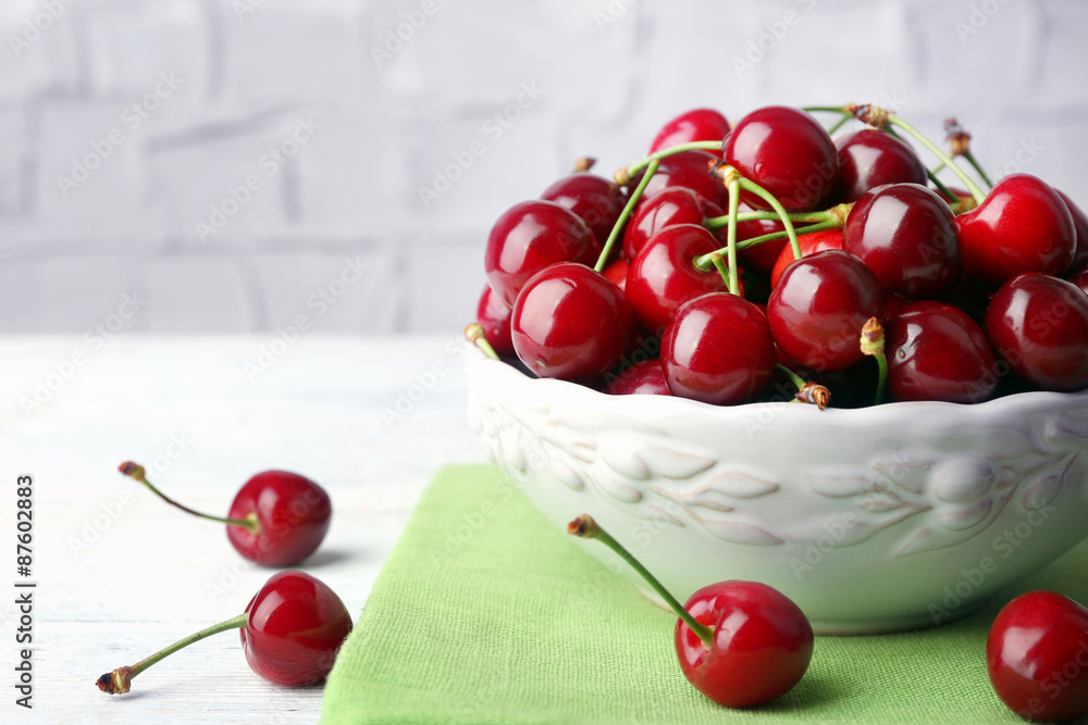 Sweet cherries in bowl on table close up