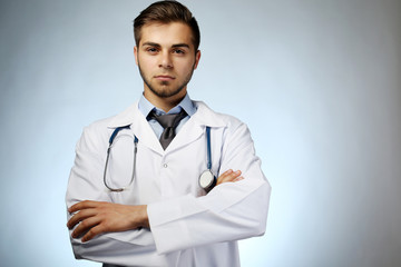 Poster - Male doctor with stethoscope on blue background