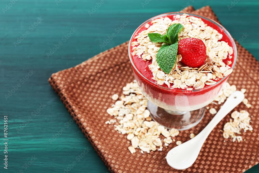Dessert with fresh strawberry, cream and granola, on wooden table background