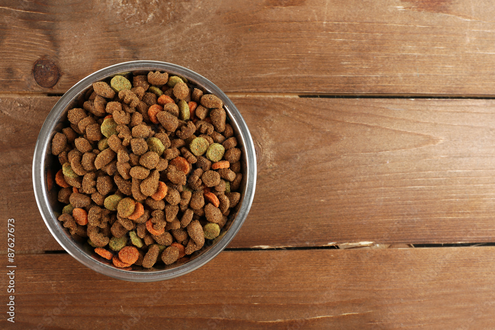 Dog food in bowl on wooden table