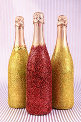 Bright bottles of champagne on paper background