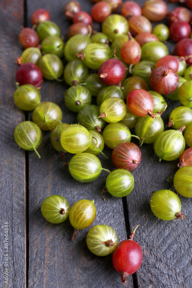 Red and green gooseberry on wooden table close-up