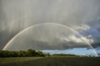 Double rainbow over a field with sunshine and rain