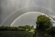Spectacular double rainbow with sunshine and rain