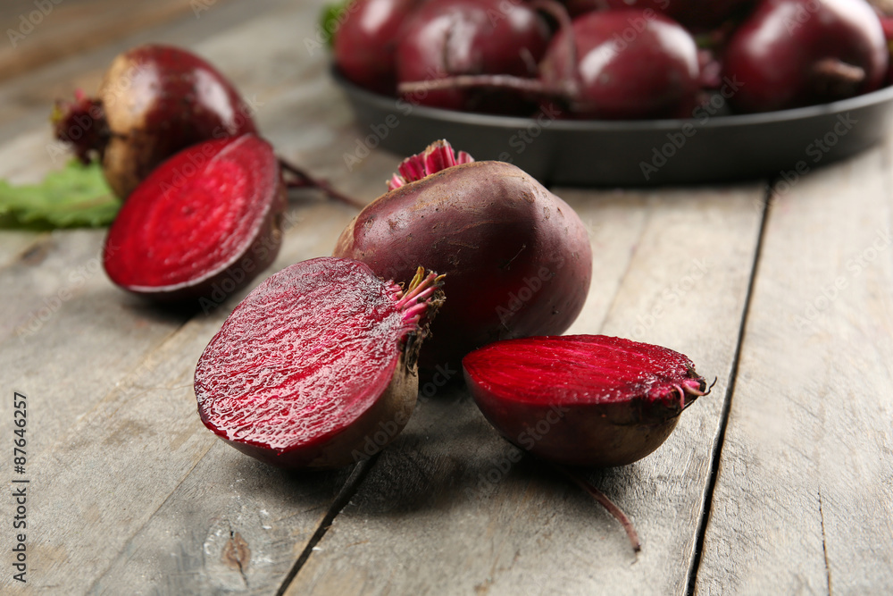 Young beets with leaves on wooden table close up