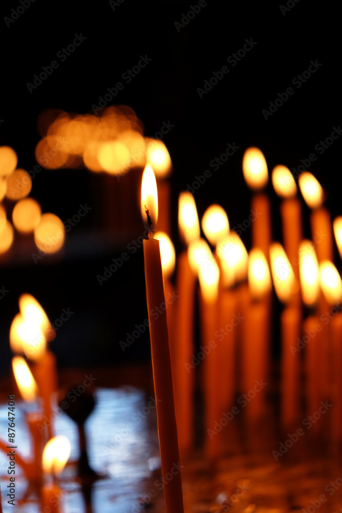 Burning church candles in dark
