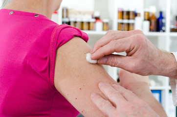 Doctor disinfecting an arm before injection