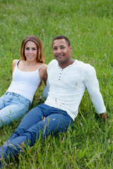 Wall Mural - Happy couple lying on the grass in the field