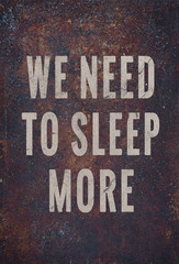 Wall Mural - Motivational poster over rusty metal WE NEED TO SLEEP MORE. 