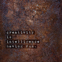 Wall Mural - Motivational poster over rusty metal CREATIVITY IS INTELLIGENCE.