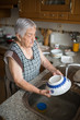 Elderly woman washing dishes