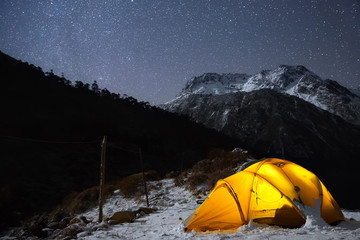 Wall Mural - camping under the light of billion stars. a starry night sky high in the mountains and a tent.