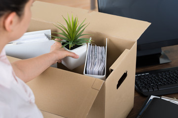 Businesswoman Packing Belongings In Cardboard Box