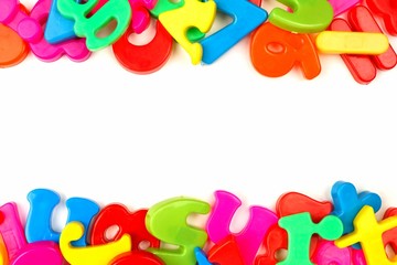 Double border of toy magnetic letters and numbers over a white background