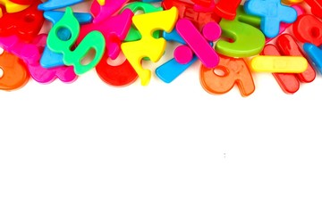 Top border of toy magnetic letters and numbers over a white background