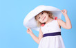 © morrowlight - Pretty little girl holding summer hat on blue