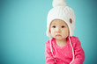 Little baby in knit winter clothing closing face with knitted be