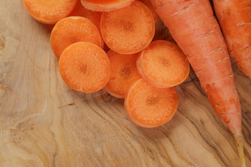 sliced organic carrot on olive wood cutting board