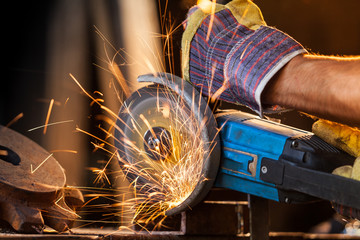 Close-up of worker cutting metal with grinder