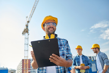 Wall Mural - builder in hardhat with clipboard at construction