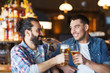 © Syda Productions - happy male friends drinking beer at bar or pub
