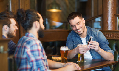 Poster - male friends with smartphone drinking beer at bar