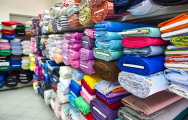 Wall Mural - Rolls of fabric and textiles in a factpory shop.