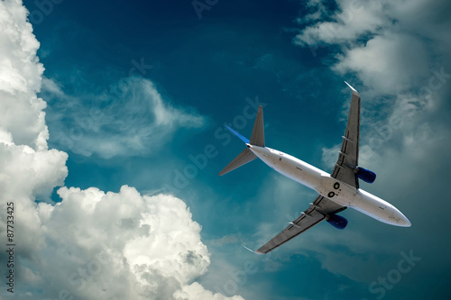 Fotografie, Obraz Airplane at flying under sky with clouds