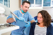 © Production Perig - Young attractive dentist explaning his work to a patient