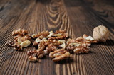 Fototapeta  - Walnut kernels and whole walnut on rustic old wooden table