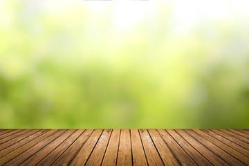 Wall Mural - wooden floor with green nature blurred background