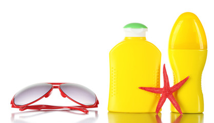 Bottles of suntan cream with sunglasses and sea star isolated on white