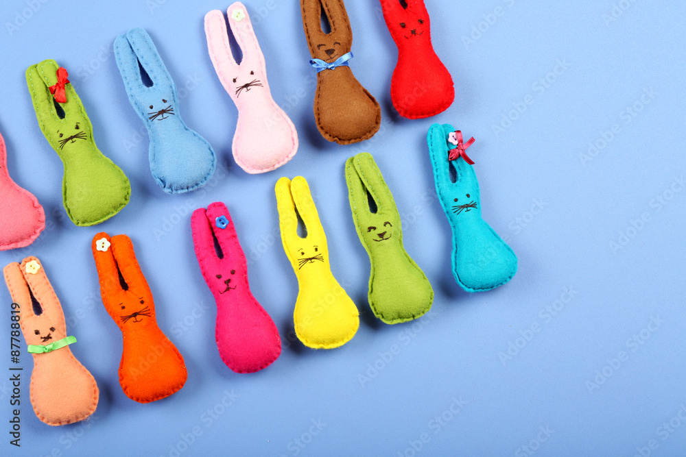 Handmade Easter rabbits on color table, top view