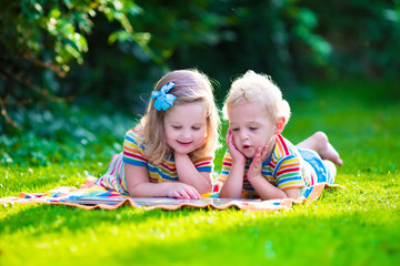 Wall Mural - Two kids reading in summer garden