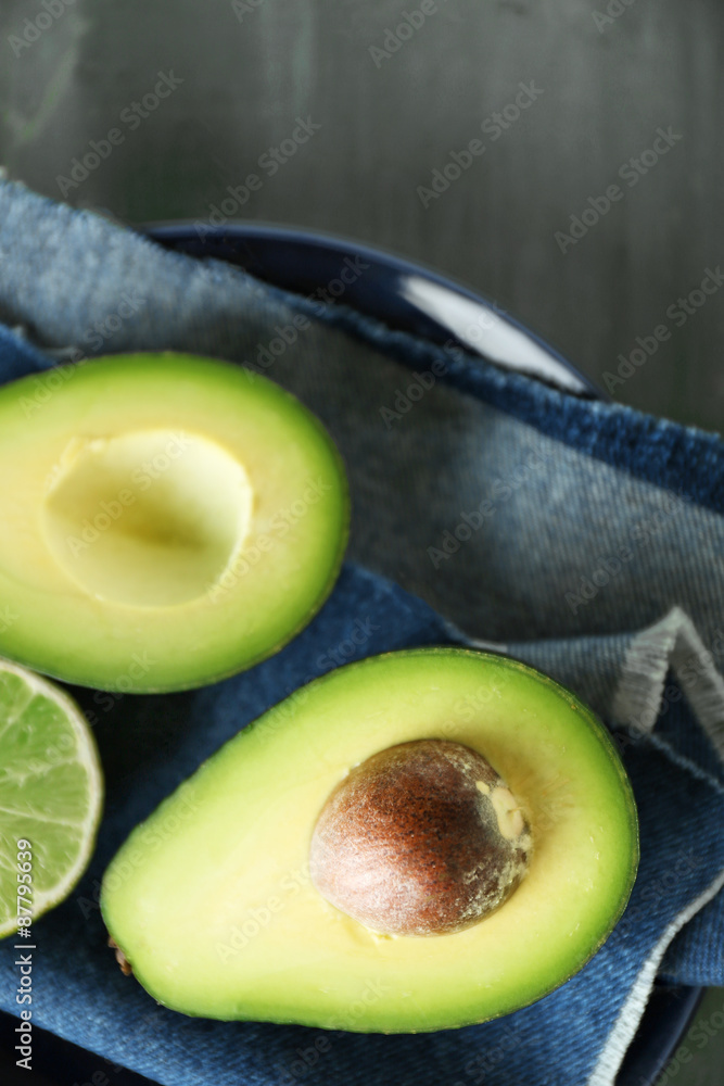 Sliced avocado and lemon lime on wooden background