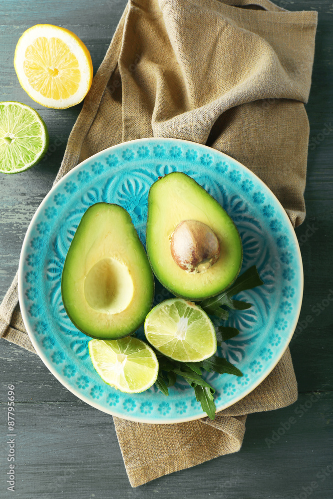 Sliced avocado and lemon lime on wooden background