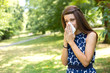 © michael spring - young woman blowing her nose in the park