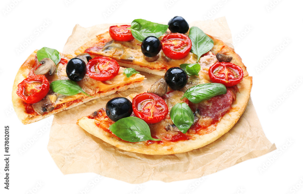 Tasty pizza with vegetables and basil on paper isolated on white