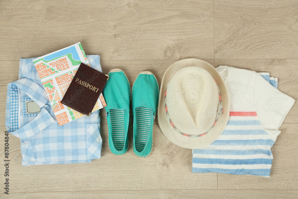 Summer vacation clothes, shoes and hat on wooden background