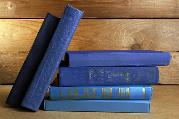 Poster - Old blue books on shelf, close-up, on dark wooden background