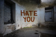 text hate you on the dirty old wall in an abandoned ruined house