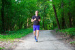 © Ruslan Mitin - A young man running in the green park