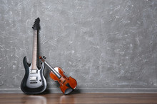 Electric Guitar And Violin On Gray Wall Background