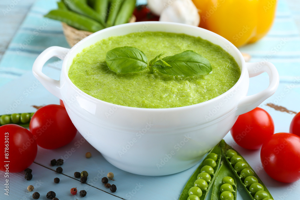 Tasty peas soup and vegetables on table close up
