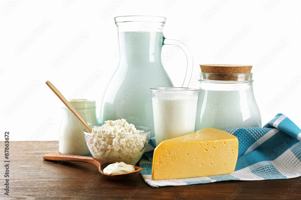 Dairy products on wooden table on white background